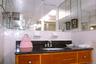 Basement bathroom with wood-finish vanity with drawer storage, dark stone-finish countertop, and a built-in sink basin