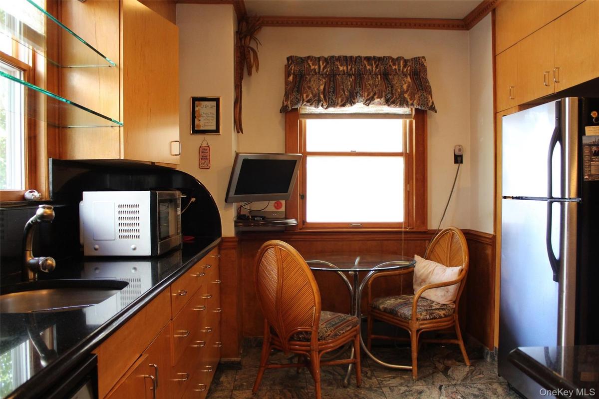 Birch wood-finish cabinetry with  trash compactor in sink   and granites tiles.All stainless steel  appliances