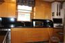 Birch wood cabinetry with built-in dishwasher, and a window with glass shelving
