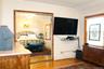 Bedroom 1 has hardwood flooring, crown molding, and a stained glass window detail with large closet