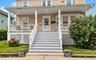 Covered front porch with white railings and lattice skirting