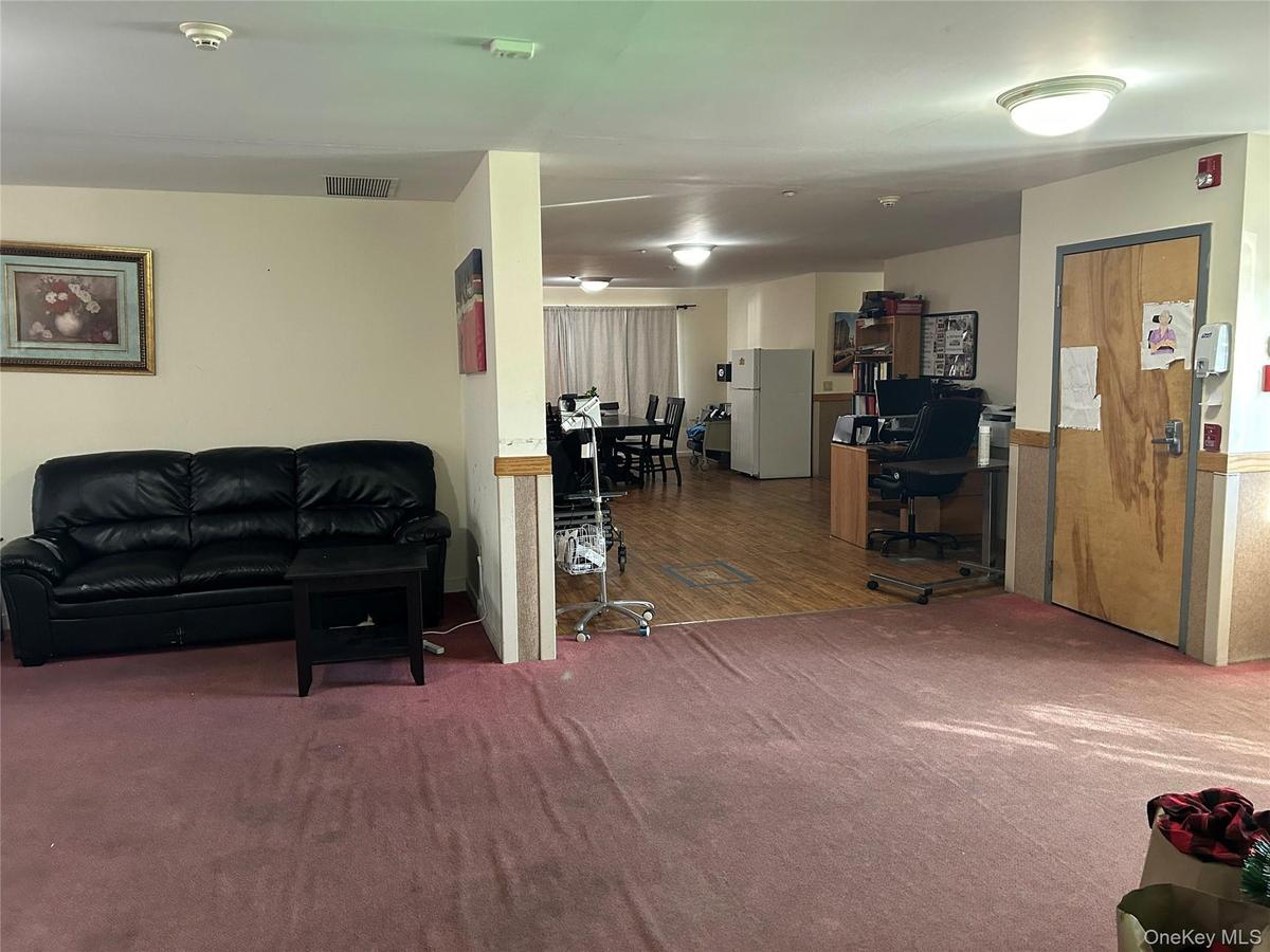 Living room with a desk and carpet floors