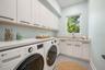Virtually staged first-floor laundry room offering generous workspace, storage, and everyday convenience.