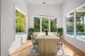 Virtually staged dining nook with elegant shiplap detailing, overlooking the private, beautifully landscaped backyard and pool.