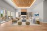 Virtually staged family room featuring a modern fireplace and custom built-ins, opening seamlessly to the outdoor entertaining area.