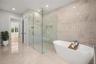 Virtually staged primary suite features a luxurious spa-inspired bath with soaking tub, spacious walk-in shower, designer tile, beautifully curated fi