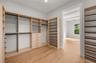 Primary bedroom walk in closet with built in closet system.