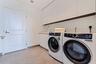 A dedicated laundry room with Electrolux washer and dryer, sink, and generous built-in storage.