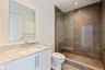 Marble finishes and a glass-enclosed shower complete the guest bath.