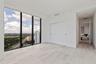Bedroom Two sits just beyond the den, wrapped in natural light with motorized shades for privacy at a touch.
