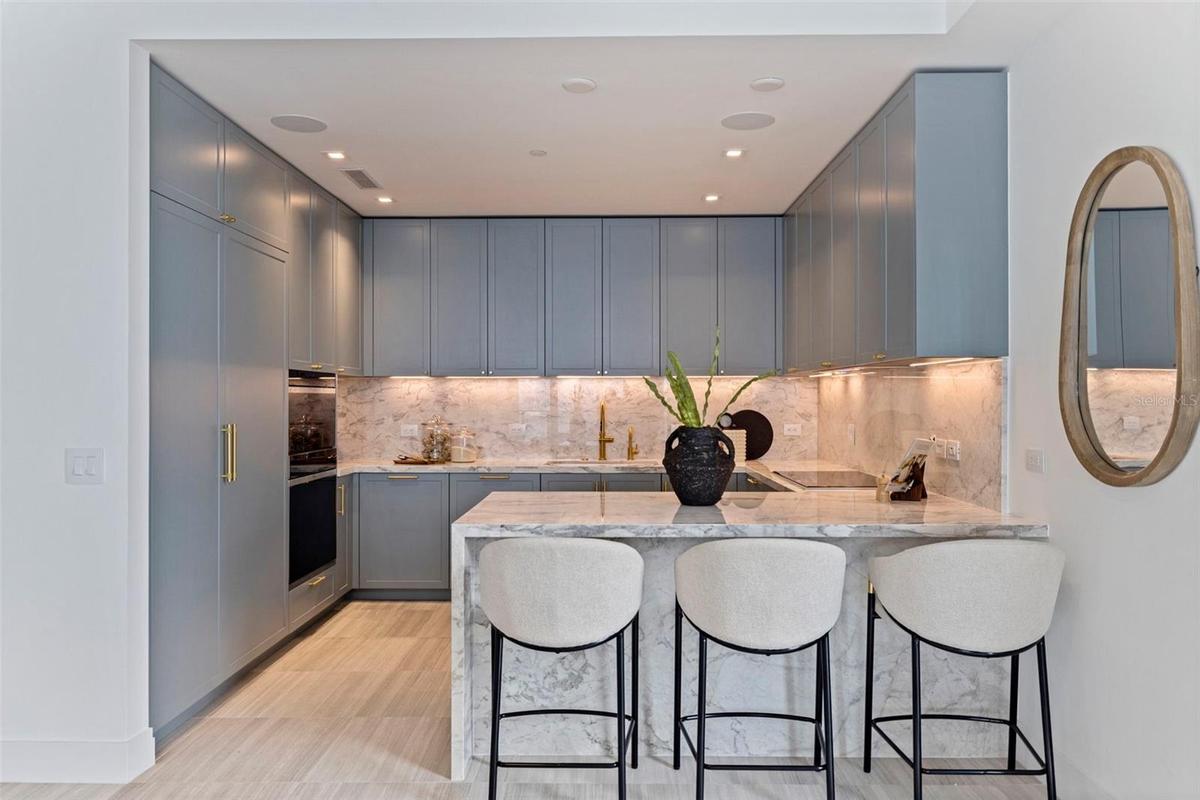 Ritz-Carlton blue cabinetry, luminous marble, and refined detailing give the kitchen its unmistakable presence.