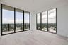 Corner glass, open sky, and a balcony just beyond—guest living with a view.