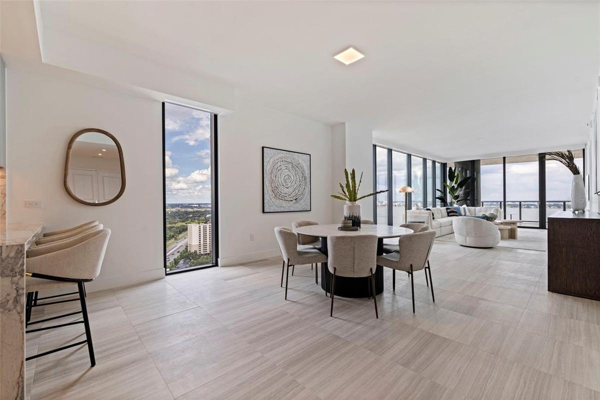 Open-concept living framed by floor-to-ceiling glass and elevated views.
