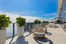 Indoor-outdoor living continues across an expansive waterfront terrace.