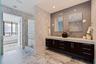 A serene primary bath where sculptural finishes, rich marble, and spa-like details create a true private retreat.