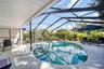 Pool & spa with screened enclosure for year-round enjoyment plus lush landscaping for privacy~