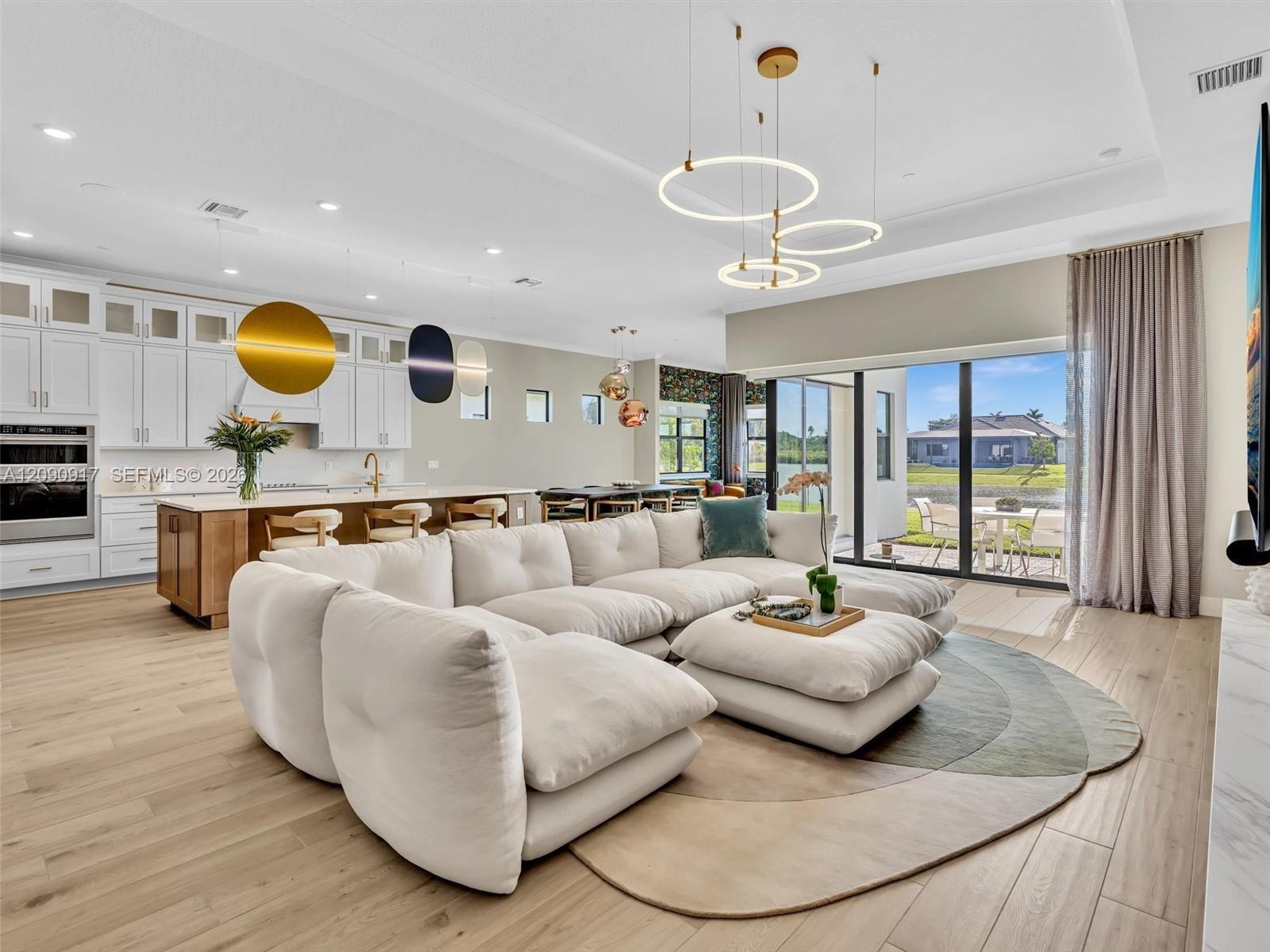 Living room, dining area and sun room look out to the lake