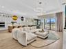 Living room, dining area and sun room look out to the lake