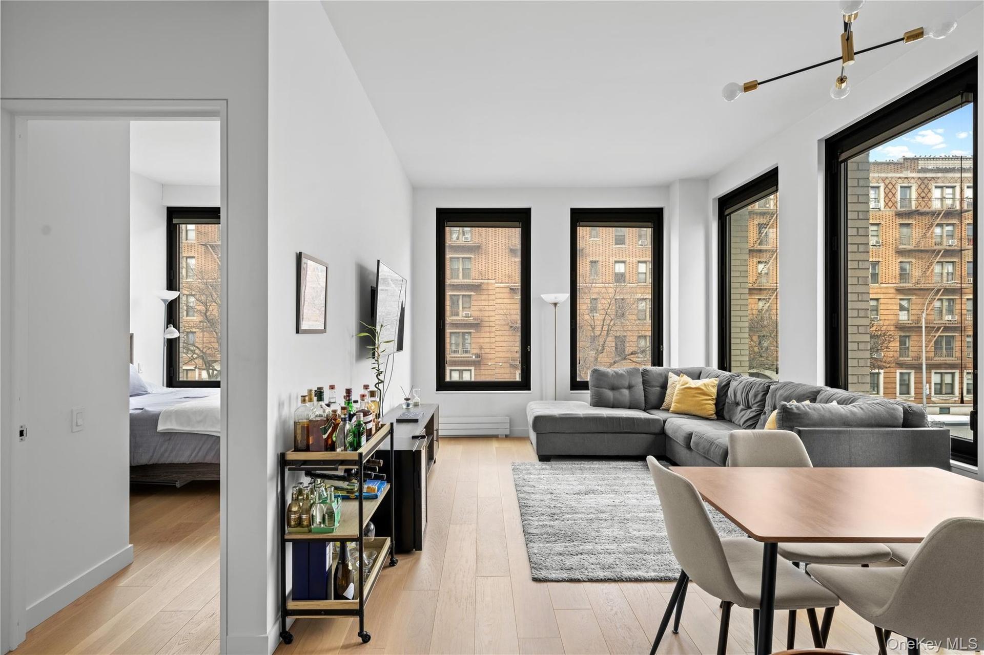 Living room with light wood-style floors, plenty of natural light, and a baseboard heating unit