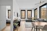 Living room with light wood-style floors, plenty of natural light, and a baseboard heating unit