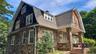 Stone-clad exterior with a gambrel roof and dormer windows