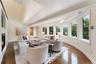 Family room with wall o curved windows overlooking patio and garden