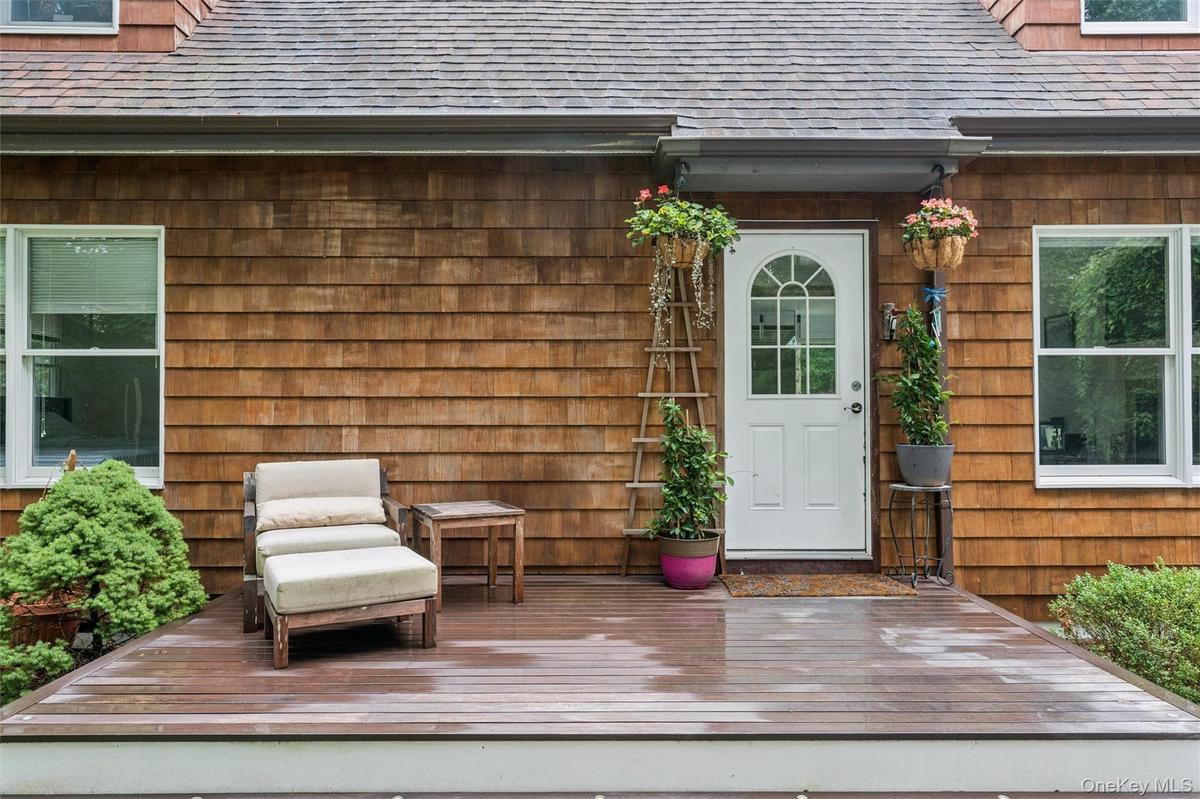 Wood-shingle exterior with white trim windows and a white arched-pane door
