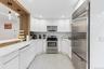 Modern kitchen featuring white glossy cabinetry, stainless steel appliances, a white countertop, and recessed lighting