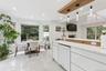 White tile flooring, bay window, recessed lighting, and a modern kitchen island with an integrated dishwasher