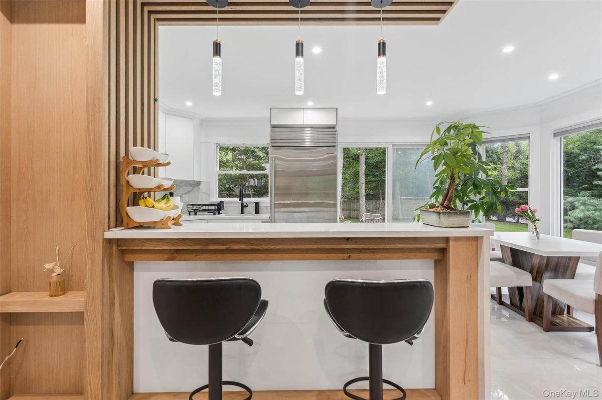 Kitchen pass-through featuring a wood-finish bar and white countertop