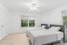 White walls, light wood-finish flooring, and a ceiling fan