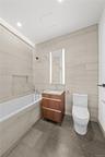 Bathroom featuring vanity, tile walls, tiled shower / bath combo, and dark tile patterned floors