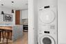 Washroom featuring stacked washer and clothes dryer and light wood finished floors