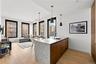 Kitchen featuring decorative light fixtures, modern cabinets, light wood-style floors, a peninsula, and brown cabinetry