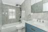 Bathroom featuring tile walls, shower / bath combination, vanity, and ornamental molding