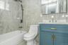 Full bathroom featuring bathing tub / shower combination, vanity, tile walls, and tile patterned flooring