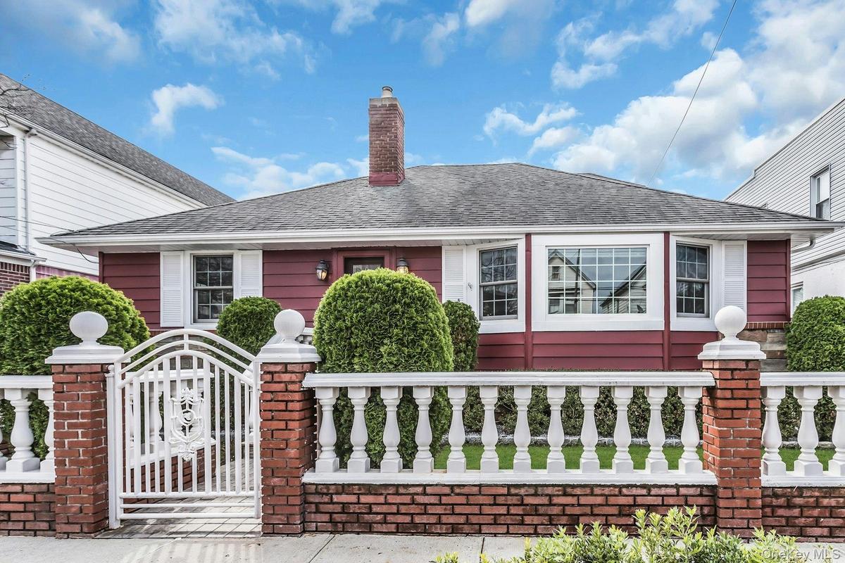 Red exterior siding with white window trim and shutters
