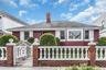 Red exterior siding with white window trim and shutters