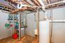 Utility area featuring a water heater, hydronic heating system, and extensive copper piping