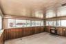Sun Room featuring wood paneling, multiple windows, and a black cast iron stove