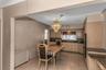 Kitchen featuring light wood-finish cabinetry, granite countertops, tile flooring, and a built-in double oven