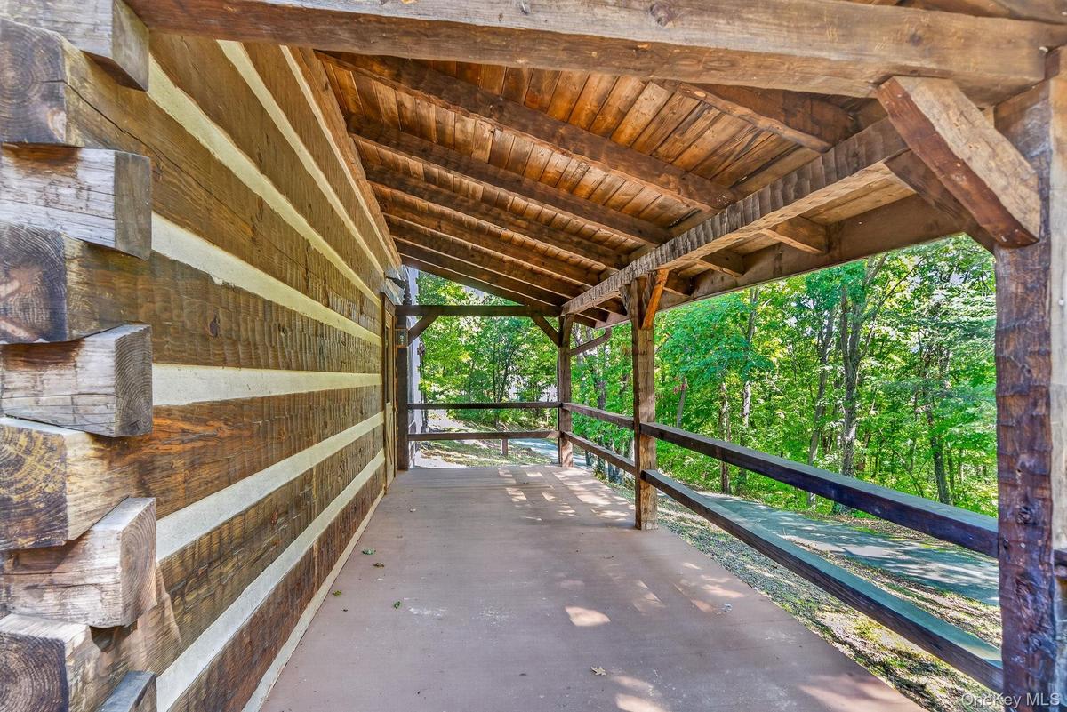 Front porch looking to driveway.  Classic dovetail notched corners.  Hand-hewn beams.