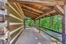 Front porch looking to driveway.  Classic dovetail notched corners.  Hand-hewn beams.