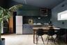 Kitchen with stainless steel appliances, light wood-type flooring, under cabinet range hood, modern cabinets, and light countertops