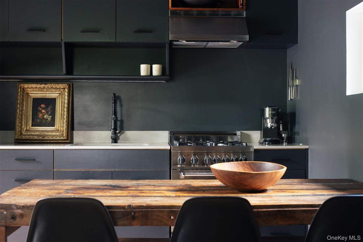 Kitchen with extractor fan, stainless steel gas stove, and gray cabinets