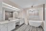The owner's ensuite bath has a large vanity with dual sinks and plenty of storage, an elegant freestanding slipper tub, separate shower, and private w