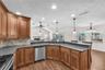 This chefs kitchen features custom wood cabinetry with crown molding, Level 5 granite countertops, and a natural stone backsplash.