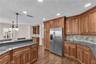 At the heart of the home, the spacious kitchen features custom wood cabinetry, Level 5 granite countertops, stone backsplash and stainless steel appli