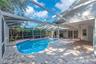 Step outside to your own backyard retreat, where the spacious screened lanai surrounds a sparkling pool and spa accented by elegant pavers.