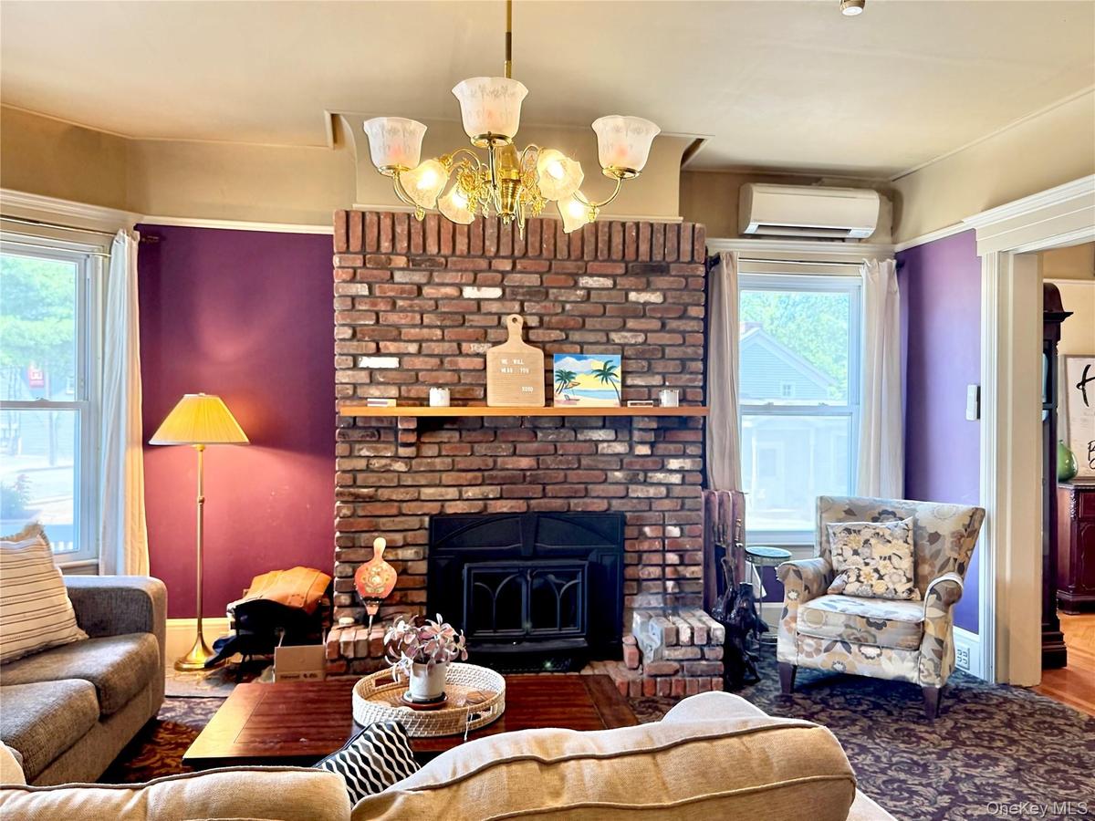 Main House Living Room Brick fireplace with two large windows